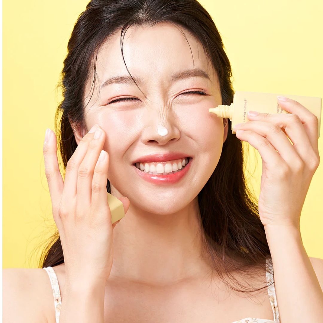 "Model applying House of Hur Weightless Sun Fluid to her cheek, showcasing its smooth, non-greasy finish."

